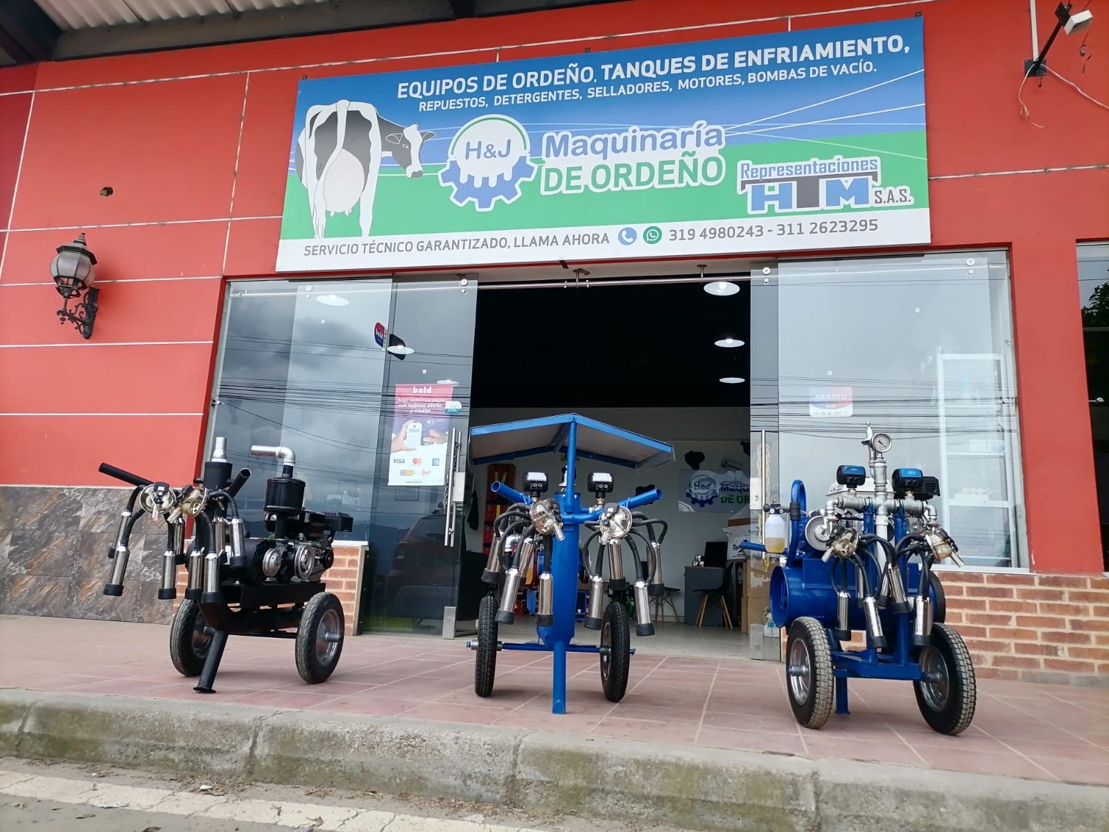 Fachada del local H&J Maquinaria de Ordeño en Zipaquirá con máquinas portátiles en exhibición